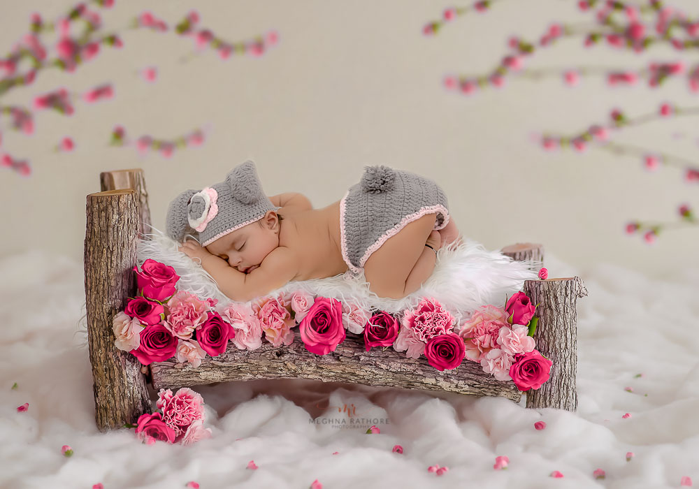 delhi professional baby photoshoot baby lying on a wooden log bed with white fur meghna rathore photography
