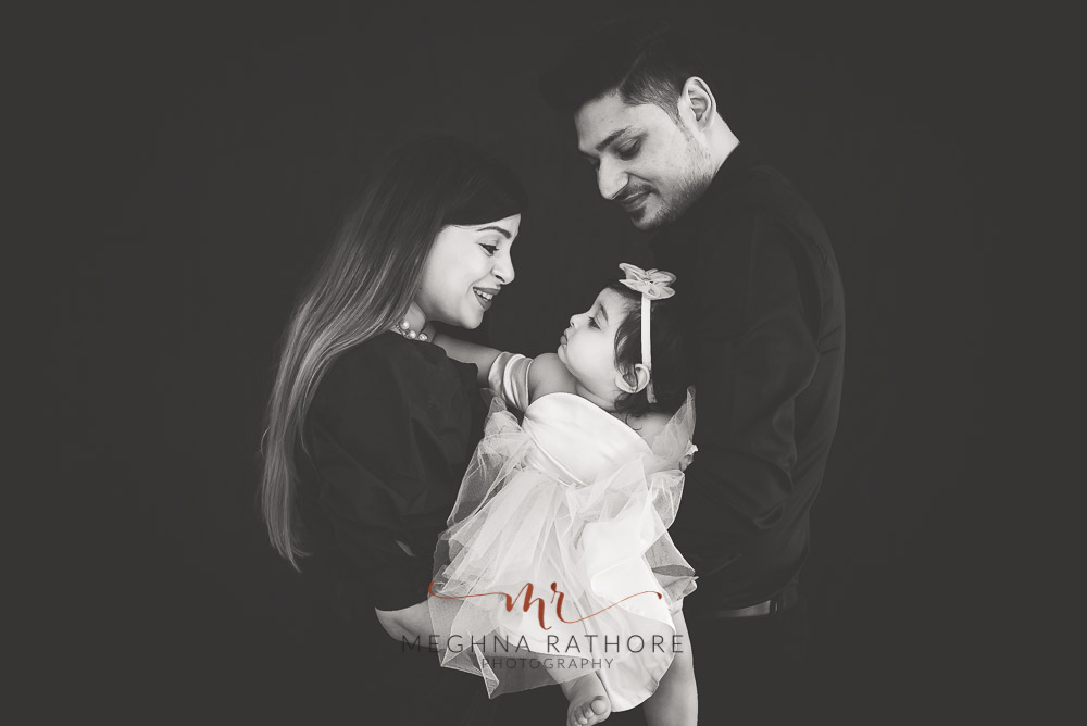 Black and white family portrait with one year old baby girl all posing at meghna rathore photograhy in delhi gurgaon