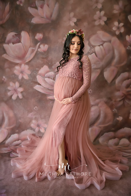 Professional shoot of Mother in peach gown during maternity shoot with floral background in Delhi