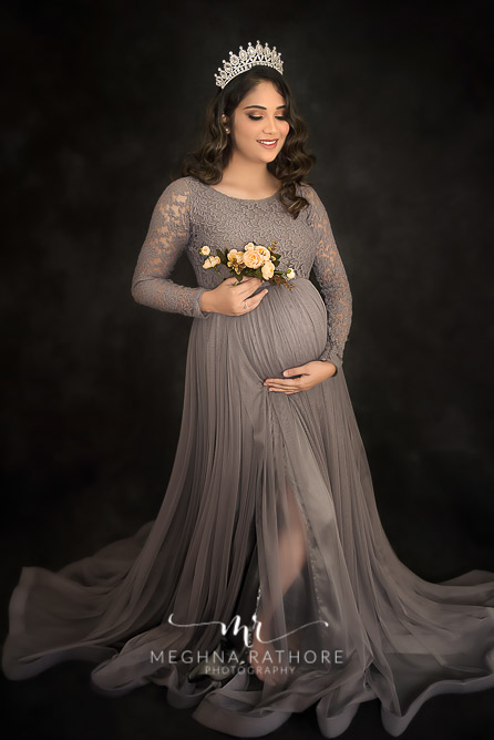 expecting mother holding her tummy while posing for maternity photo shoot meghna rathore photography