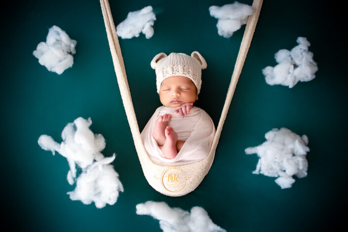 Newborn baby in white hat and blanket, peacefully sleeping captured by Delhi NCR's best maternal photographer Meghna Rathore.