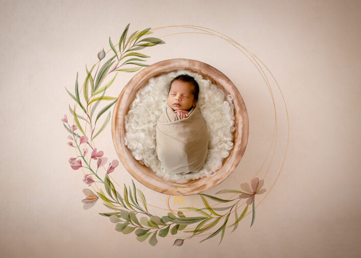 A newborn baby girl peacefully rests in a wooden bowl adorned with delicate floral patterns captured by Delhi NCR's best maternal photographer Meghna Rathore.