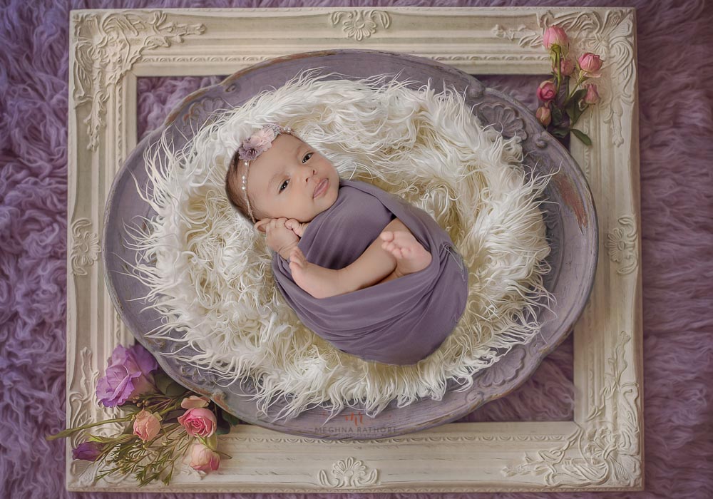delhi gurgaon newborn baby professional photographer baby wrapped in a wrap lying on fur meghna rathore photography