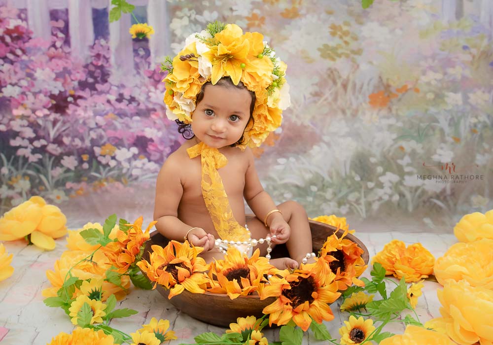 delhi gurgaon professional kid photoshoot kid sitting in a basket with floral decoration meghna rathore photography