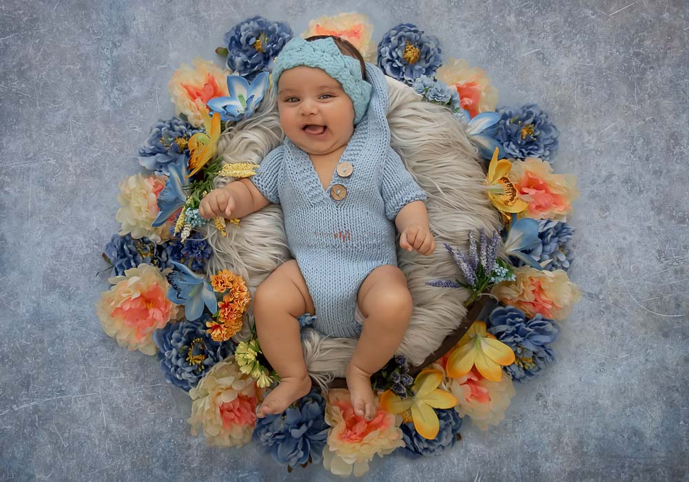 delhi gurgaon professional baby photographer baby in basket with floral decoration blue background meghna rathore photography