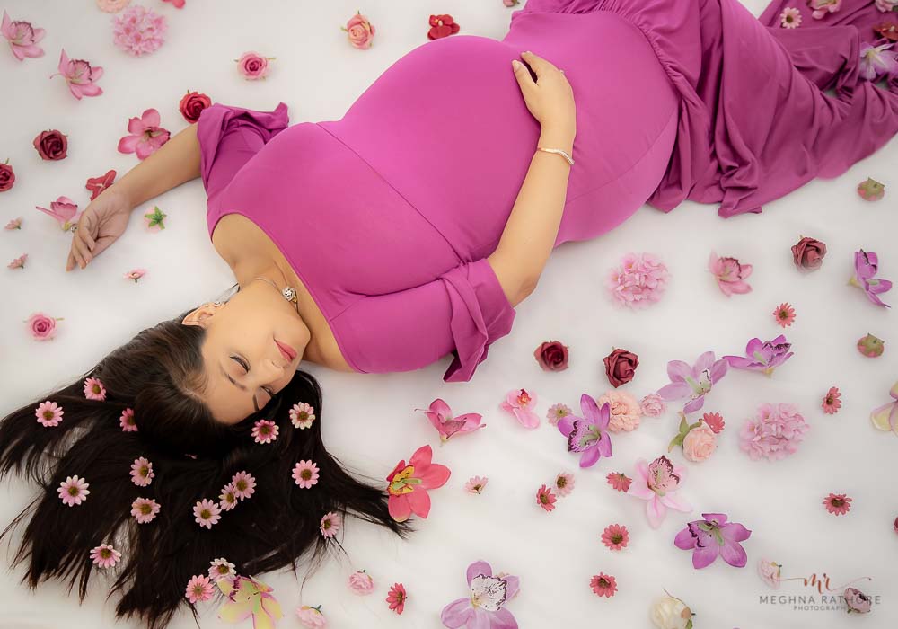 delhi gurgaon maternity photography mother lying on the floor with flowers around meghna rathore photography