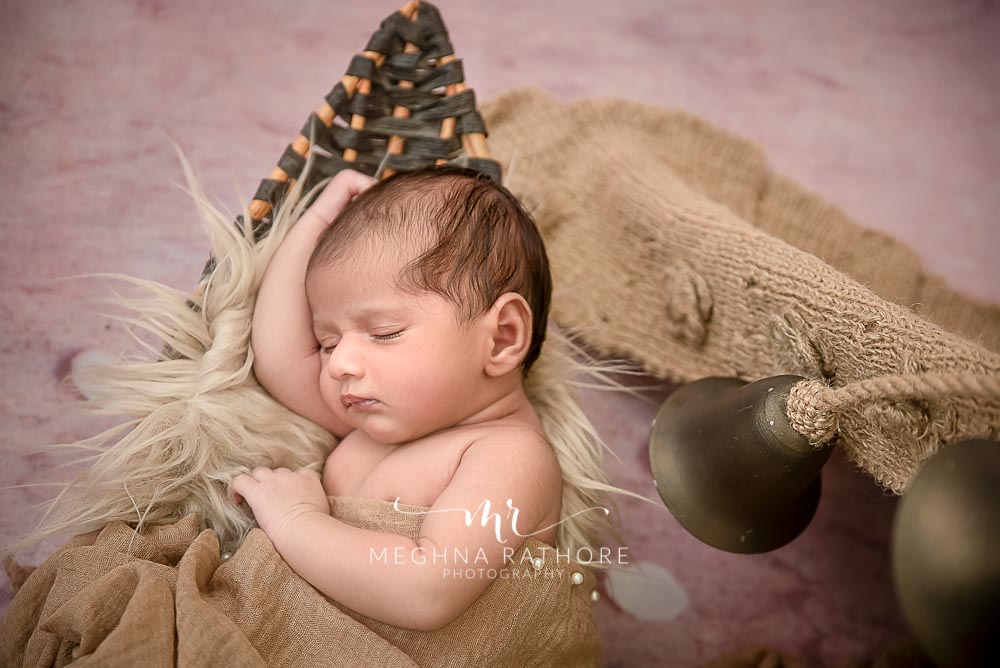 Newborn baby boy peaceful sleeping pose with props around hi at meghna rathore photography in delhi