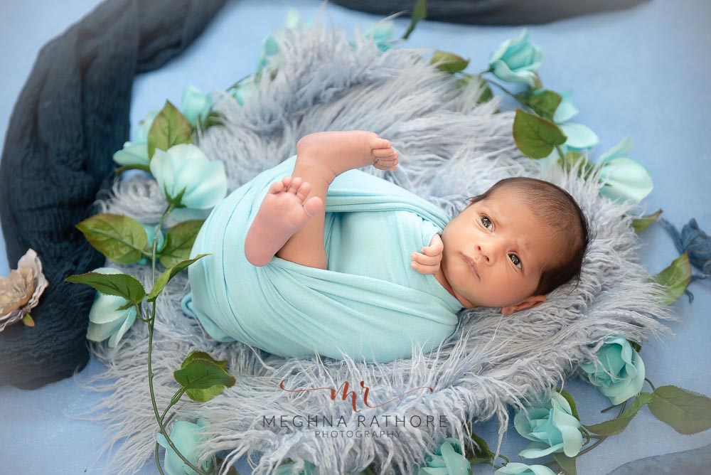23 days old newborn baby boy posing brightly inside a grey colored furry blanket in a basket at meghna rathore photography in delhi