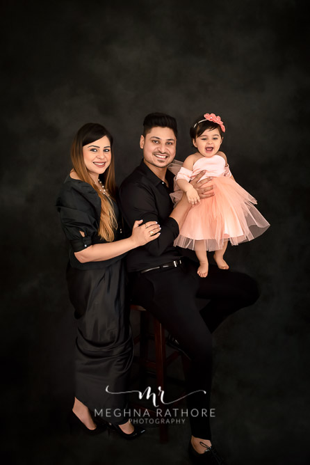 Family portrait with one year old baby girl all posing and smiling at meghna rathore photograhy in delhi gurgaon