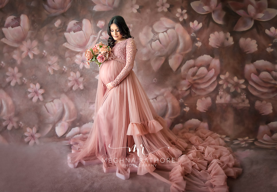 Professional shoot of Mother in peach gown during maternity shoot with floral background in Delhi