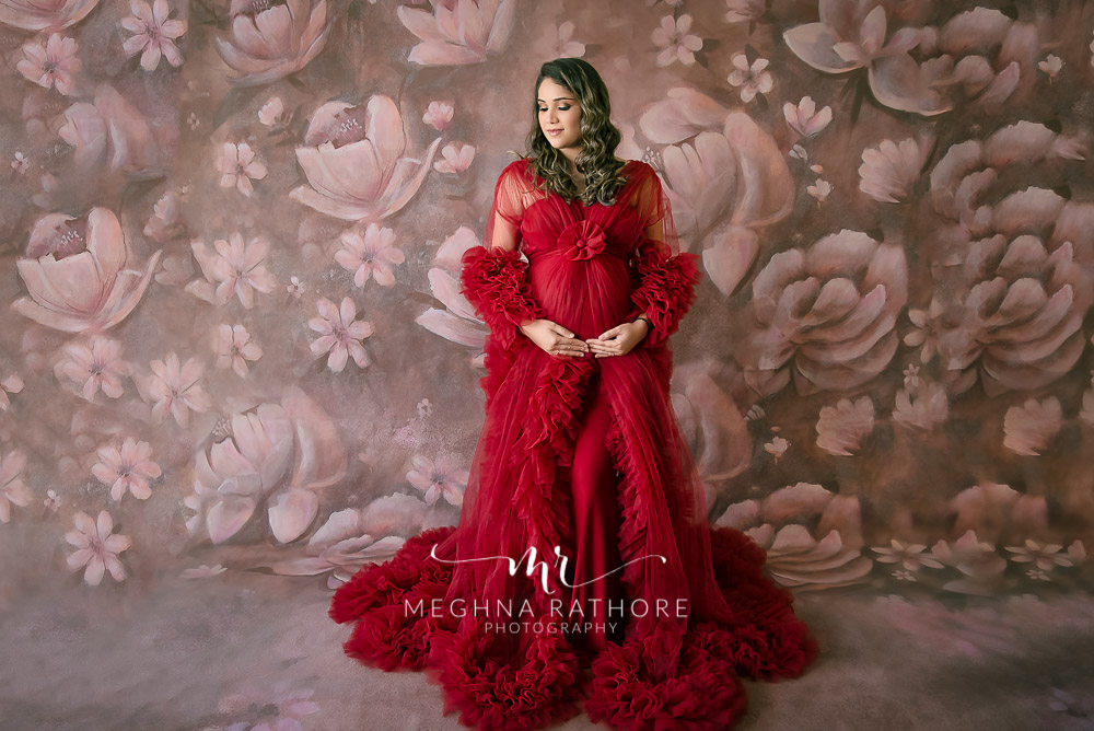 lady in red dress posing for maternity photo shoot meghna rathore photography