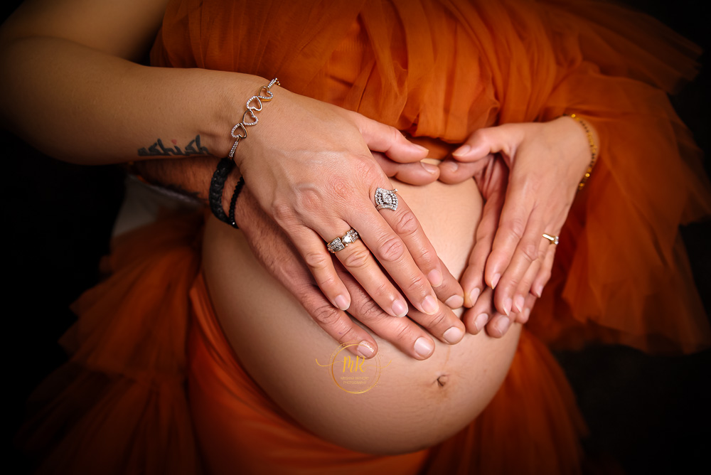 maternity photoshoot ideas at home .. holding couple hand on tummy shoot by best maternity photographer