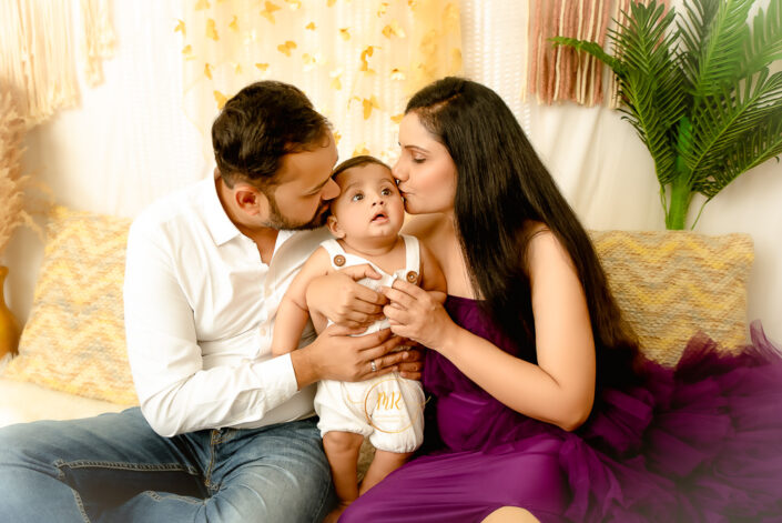 A baby boy is kissed by his mother and father on his cheeks captured by Meghna Rathore, Delhi NCR's best maternity and child photographer.