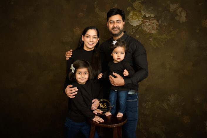A family of four consisting a couple and their two child posing for their family photoshoot captured by Meghna Rathore best maternal and child photographer in Delhi, NCR.