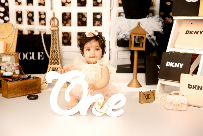 A baby girls seems like having shopping for first year birthday in France surrounded with French brands bags, captured by Meghna Rathore best maternal and child photographer in Delhi, NCR.