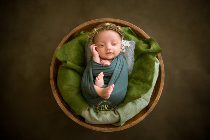 A little baby girl with beautiful tiara in a wooden bowl and the moment was captured by Meghna Rathore best child photographer in Delhi NCR, Haryana