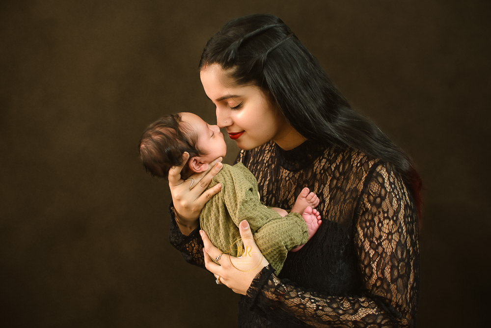 A mother holding her newborn baby, displaying a heartwarming moment of parental care and affection